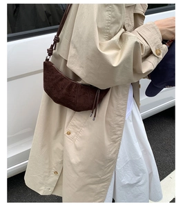 Détail du sac croissant en daim marron foncé avec nœud de bandoulière en style urbain