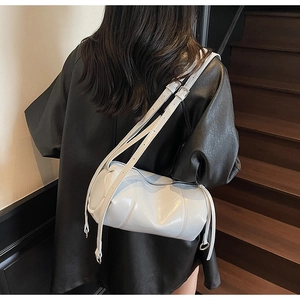 Close-up of light blue barrel bag with high-gloss finish and silver metal buckle details