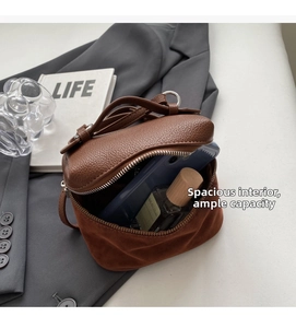 Detailed interior view of a brown pebbled leather crossbody bag showing large storage capacity