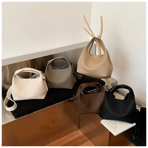 Minimalist bucket bags displayed in five colors with top handles and shoulder straps