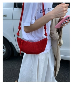 Sac demi-lune en daim rouge avec détail de nœud et fermeture éclair en extérieur