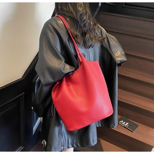 Macro view of bright red lychee grain leather tote bag with large storage capacity