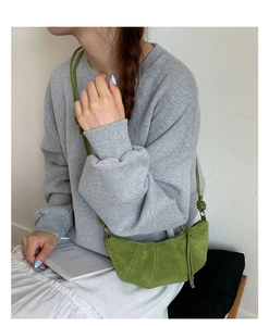 Sac croissant vert avocat avec bandoulière tressée porté par un mannequin