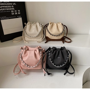 Group of textured fabric bucket bags in beige, brown, pink, and black with silver chains