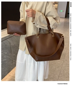 Close-up of brown leather tote bag set with pebble texture and gold ring hardware