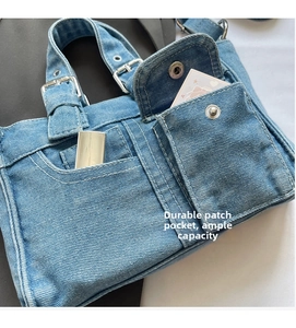Detail of vintage denim handbag featuring functional cargo pockets and metal rivets