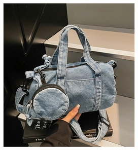 Dettaglio borsa Boston in denim blu con tracolla e ciondolo mini portafoglio rotondo