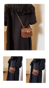 Detailed view of brown two-tone crossbody bag with leather and suede textured stitching