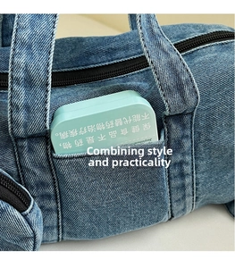 Dettaglio della borsa a tracolla in denim lavato che mostra una tasca laterale funzionale