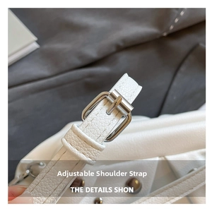 Détail de la bandoulière réglable avec boucle argentée sur un sac en cuir blanc