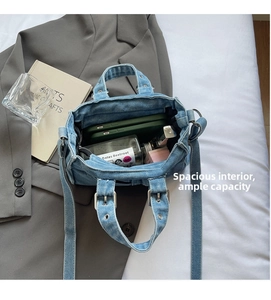 Top view of denim tote bag showing spacious interior with silver studs and accessories