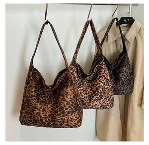 Trois grands sacs cabas léopard en marron, beige et gris suspendus sur un portant