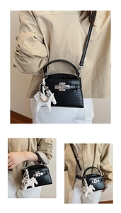 Detail of black crocodile texture handbag with silver lock and white horse charm
