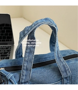 Detailed close-up of denim handbag with sturdy handles and premium zipper closure