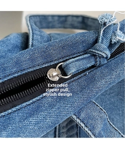 Dettaglio della cerniera allungata sulla borsa tote in denim blu con cuciture