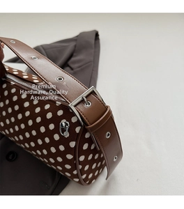 Detail of vintage polka dot pillow bag with silver buckle and leather shoulder strap