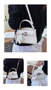 Detail of white crocodile pattern Kelly bag with strap and leather horse charm accessory