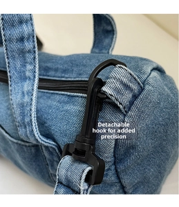 Close-up of the detachable black hook and denim fabric texture on the cylindrical bag
