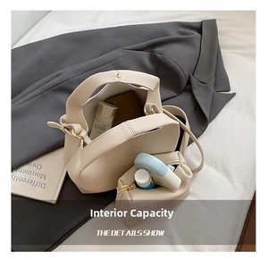 Interior capacity of chic off-white bucket bag showing daily essentials and pouch