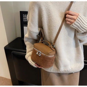 Brown mini box bag in textured leather and suede shown on a beige knit sweater outfit