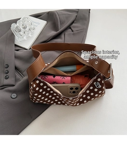 Spacious interior of brown polka dot canvas bag with leather trim and daily essentials