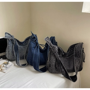 Three vintage denim hobo bags in blue and grey washes with stylish knot shoulder straps