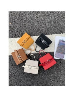Overhead view of mini square handbags in five colors on a textured outdoor background