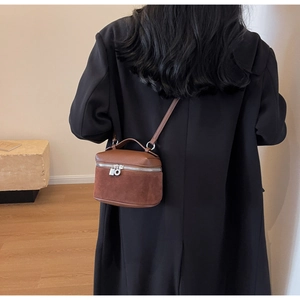 Detail of vintage matte crossbody box bag shown on model with brown leather contrast