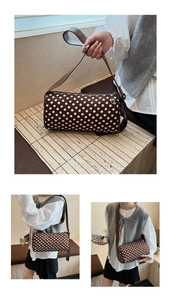 Detailed view of coffee brown polka dot cylinder bag with slender shoulder strap