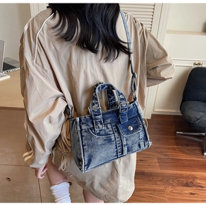 Vue détaillée du sac bandoulière en denim délavé vintage porté par un mannequin réel