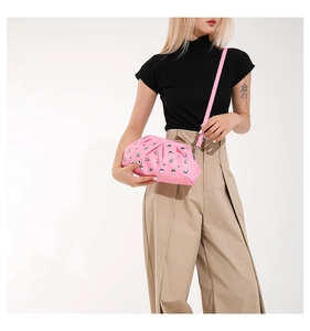 Détail d'un sac dumpling rose avec rivets argentés et texture plissée élégante