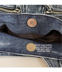Macro shot of retro bronze magnetic snap button and zipper on blue denim tote bag