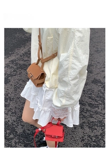 Street style shot of mini PU leather square bags in brown and red used as fashion charms