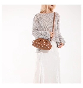 Gros plan d'un sac hobo marron en similicuir orné de rivets argentés de style punk