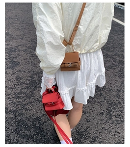 Mini square handbags in red and brown leather shown in a street style perspective