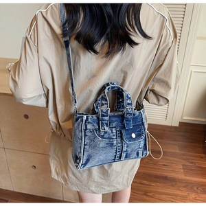 Model view showing the back profile and fit of the vintage washed denim crossbody bag