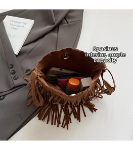 Vue intérieure montrant la capacité du sac seau en daim marron avec franges et fermeture