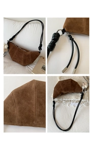 Détails du sac croissant en daim marron montrant les coutures et les nœuds