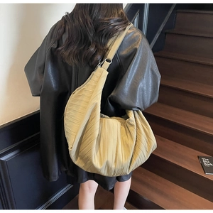 Detailed view of khaki pleated hobo bag showing dense vertical textures and spacious design