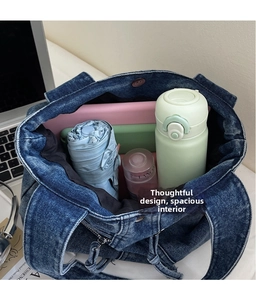 Top view showing large capacity interior of blue denim tote bag with daily essentials