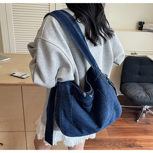 Close-up of vintage deep blue denim tote with raw edge detail and thick washed fabric