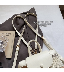 Detail of a cream woven backpack featuring a smooth adjustable shoulder strap and metal buckle