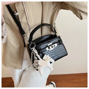 Detail of black croc-embossed handbag with silver hardware and horse charm