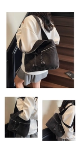 Detail of black washed denim tote bag showing multiple utility zippers and woven drawstring