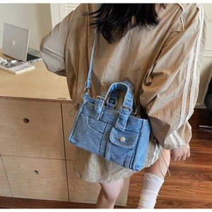 Vue détaillée de la texture denim délavé et de la boucle en métal de ce sac vintage