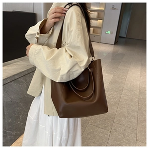 Deep brown matte leather tote bag styled with a beige trench coat for a vintage look