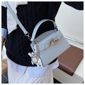 Detail of light blue crocodile embossed texture on Kelly style handbag with silver twist lock