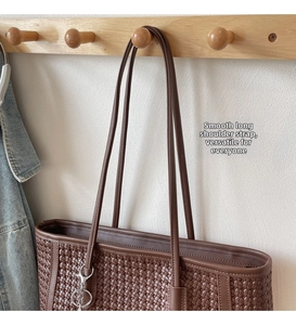Detail of the woven texture and leather shoulder straps on a brown vintage tote bag