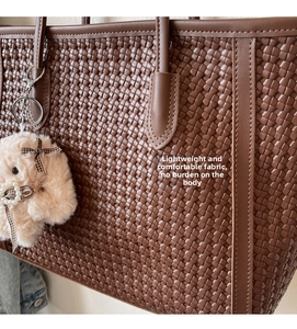 Close-up of brown woven tote bag showing intricate cross-texture and plush rabbit charm
