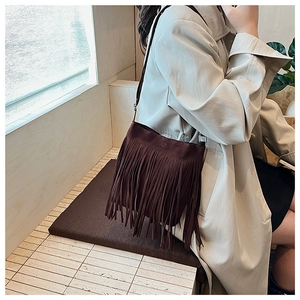 Détail du sac à bandoulière en daim marron foncé avec longues franges bohèmes